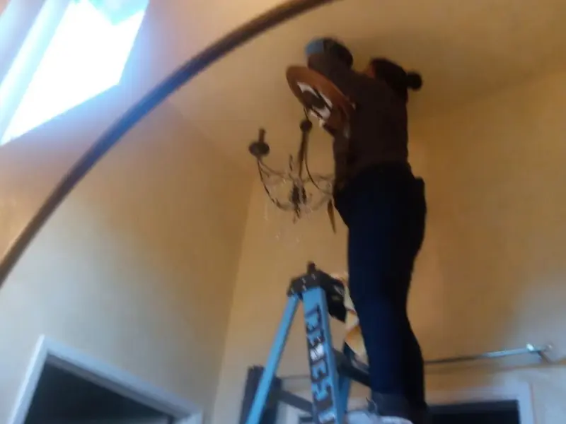 Electrician installing a chandelier in a Frostproof residence